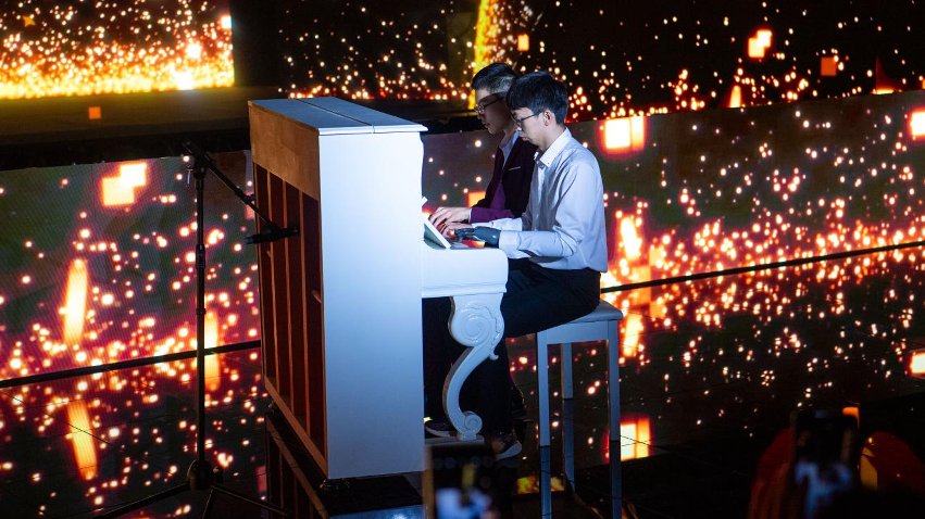 智能仿生手使用者古月與少年鋼琴家舒海峰合奏。主辦方供圖